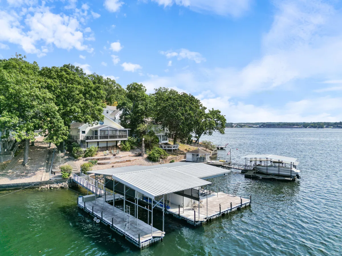 A tranquil dock set against a backdrop of trees and calm lake waters. The space is ideal for gathering, hosting summer parties, fishing, or simply watching sunsets together as a family.