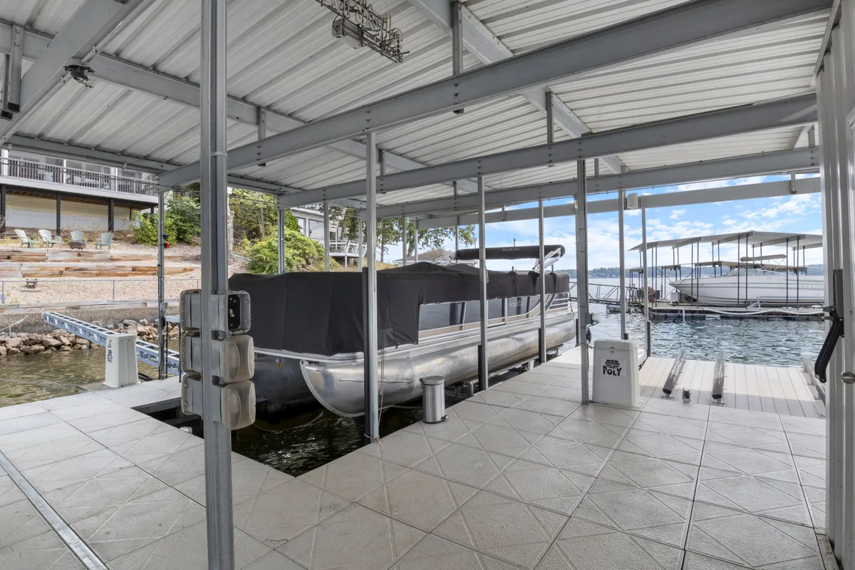 This exterior image prominently showcases a dock extending out onto the lake, with a boat moored alongside and serene water views framed by the surrounding landscape. The dock appears inviting and accessible, perfect for lakeside activities and water access.